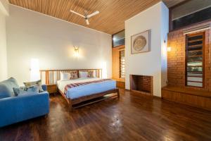 a bedroom with a bed and a couch at Asta in Ooty