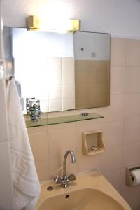 a bathroom with a sink and a mirror at Polizotou Rooms in Skala Sotiros