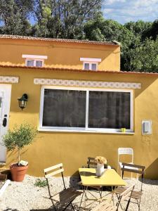 アレンケルにある3 bedrooms house with wifi at Alenquerの黄色いテーブルと椅子のある黄色い家
