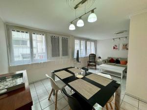 a kitchen and living room with a table and chairs at F3 Plein Cœur Centre Clermont FD avec Parking Montrognon in Clermont-Ferrand