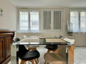 a dining room with a glass table and chairs at F3 Plein Cœur Centre Clermont FD avec Parking Montrognon in Clermont-Ferrand +7 photos