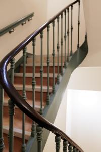 eine geschlossene Treppe mit grünen Geländern in der Unterkunft ALFRED HOTELS Port-Vieux - Ex Georges VI in Biarritz