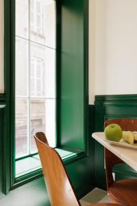 een groene kamer met een tafel en stoelen en een raam bij ALFRED HOTELS Port-Vieux - Ex Georges VI in Biarritz