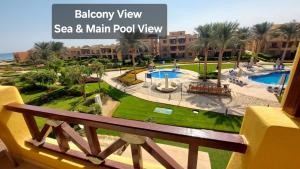 einen Balkon mit Poolblick in einem Resort in der Unterkunft Mountain View 2 Ain Sokhna, Sea & Pool View, Penthouse with Roof- Families ONLY in Ain Suchna