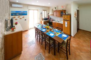 una cocina con una mesa de comedor larga con sillas en Casa Aurora en Giarre