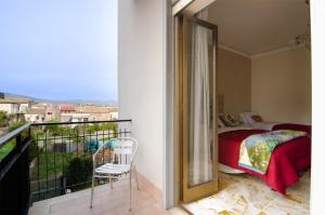 1 dormitorio con balcón con 1 cama y 1 silla en Casa Aurora en Giarre