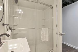 uma casa de banho branca com um chuveiro e um lavatório. em The Blue Beechwald Bungalow em Columbus