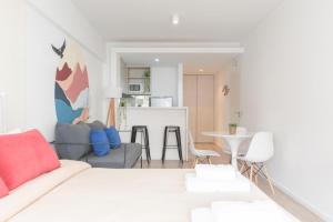 sala de estar blanca con sofá y cocina en Fliphaus Zapiola 2300 - Lux Aparts 'a' Belgrano en Buenos Aires