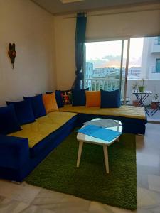 sala de estar con sofá azul y mesa en Appartement la Siesta beach resort Mohammedia en Mohammedia