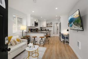 a living room with a couch and a kitchen at Brand New Designer's Modern 1BR Home 1min to I-5 in Lynnwood