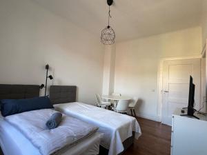 sypialnia z 2 łóżkami, telewizorem i stołem w obiekcie Altbau mit Wartberg - Blick w mieście Pforzheim