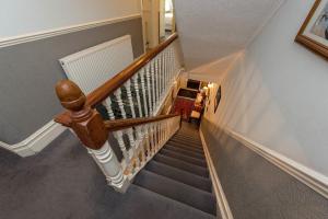 a staircase with a wooden hand rail and a stair case at The Strand Hotel in Bournemouth