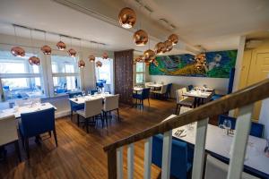 a dining room with white tables and chairs at Hotel Les Trois Soeurs in Perce