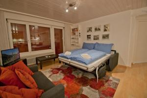 a room with a bed and a couch and a tv at Haus Arola, Apartment Hirle in Zermatt
