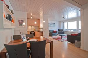 uma sala de jantar e sala de estar com mesa e cadeiras em Haus Arola, Apartment Hirle em Zermatt