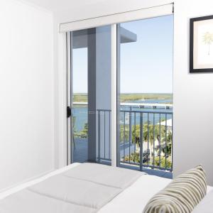 a bedroom with a bed and a balcony at Riviera Mackay in Mackay