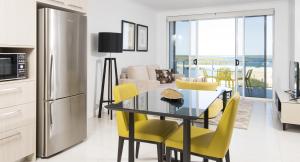 a kitchen with a refrigerator, stove, microwave and a table at Riviera Mackay in Mackay