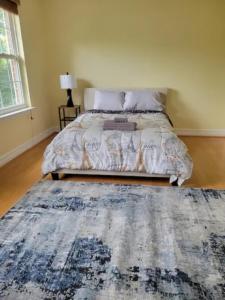 1 dormitorio con 1 cama con alfombra azul en 1 bedroom in a cheerful home with indoor fire place, en Fort Washington