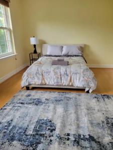 een slaapkamer met een groot bed en een blauw tapijt bij 1 bedroom in a cheerful home with indoor fire place in Fort Washington