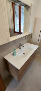 een badkamer met een wastafel en een spiegel bij Casa di Gino in Pontedera