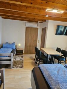 Zimmer mit 2 Betten, einem Tisch und Stühlen in der Unterkunft Gästehaus Rana in Rust