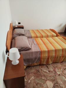 a bedroom with a bed and a table with a lamp at Casa di Gino in Pontedera