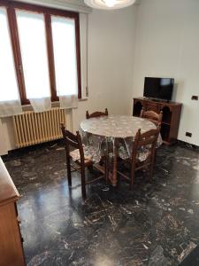 een kamer met een tafel en stoelen en een televisie bij Casa di Gino in Pontedera