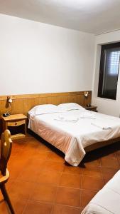 um quarto com uma cama, uma mesa e uma janela em A' Porta i Frustere em Rotonda