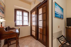 a room with a piano and a desk and window at B&B Hibiscus in Agropoli