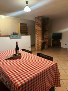 Una habitación con una mesa con una botella de vino. en Relax tra Monferrato & Langhe en SantʼAndrea