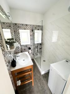 a bathroom with a sink and a shower at Ronia apartment in Kaštela +8 photos