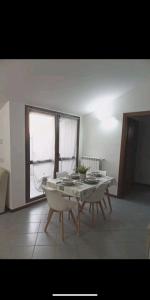 d'une salle à manger avec une table, des chaises et une fenêtre. dans l'établissement Suite Room Malpensa apartment, à Cardano al Campo