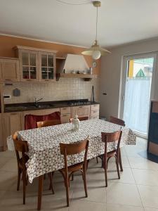 a kitchen with a table with chairs and a table and a kitchen at Casa Vecchia, ma Moderna in Villar Perosa