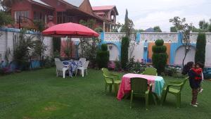 斯利那加的住宿－The Chinar Residency，两个孩子站在院子里,配有桌椅