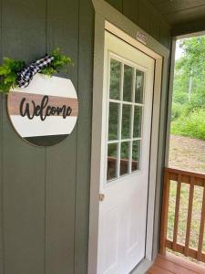 a door to a house with a welcome sign on it at Camping Cabin with private Bathroom in Maumee