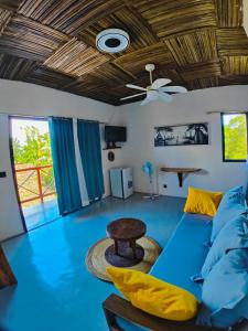 a living room with a blue couch and a ceiling at Bungalows des tropiques in Nosy Be