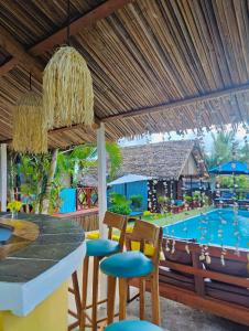 una cocina con mesa y sillas y una piscina en Bungalows des tropiques, en Nosy Be