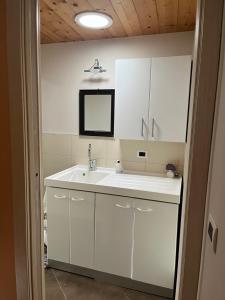 a white bathroom with a sink and a mirror at Casa Vecchia, ma Moderna in Villar Perosa