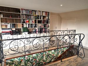 een trap met een smeedijzeren rail en boekenplanken bij Vaucelles city in Vaucelles