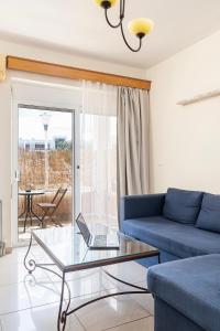 a living room with a blue couch and a glass table at The Retreat in Kos Central in Ampavris