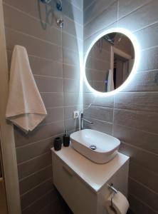 a bathroom with a white sink and a mirror at Matovic Apartments in Dobra Voda