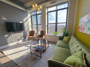 a living room with a green couch and a tv at McCormick Place 2b/2b with optional parking and gym for up to 6 guests in Chicago