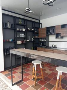 a kitchen with a large table and two stools at Deko rooms in Arauca
