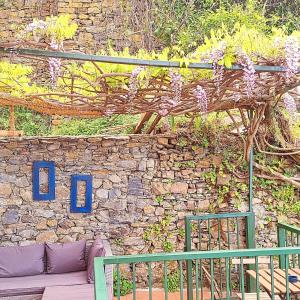 un muro di pietra con una panca di fronte a un edificio di Sunset Manarola a Manarola