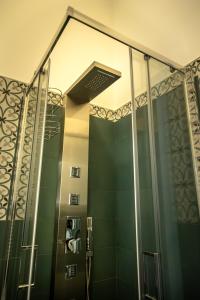 uma casa de banho com um chuveiro e uma porta de vidro em La Terrazza Nel Borgo B&B em Copertino
