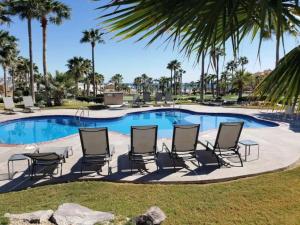 um grupo de cadeiras e uma piscina com palmeiras em Lovely 2-Bedroom Pet Friendly Sea View Haven em Puerto Peñasco