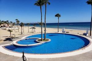 uma grande piscina azul junto à praia em Lovely 2-Bedroom Pet Friendly Sea View Haven em Puerto Peñasco