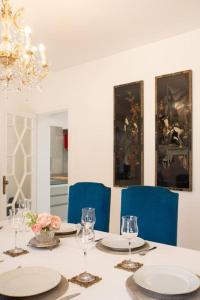 White Star Estoril في استوريل: غرفة طعام مع طاولة مع أطباق وكراسي زرقاء
