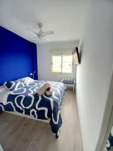 a bedroom with a bed with a blue wall at Cabo de Palos apartamento vacacional in Cabo de Palos