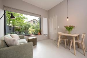 sala de estar con mesa y sofá en Cosy Dutch Delight Apartment, en Santpoort-Zuid